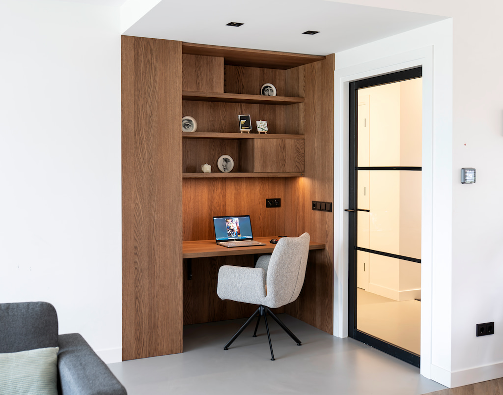 Thuiswerkplek op maat: bureau ingebouwd in een houten kastenwand met open vakken