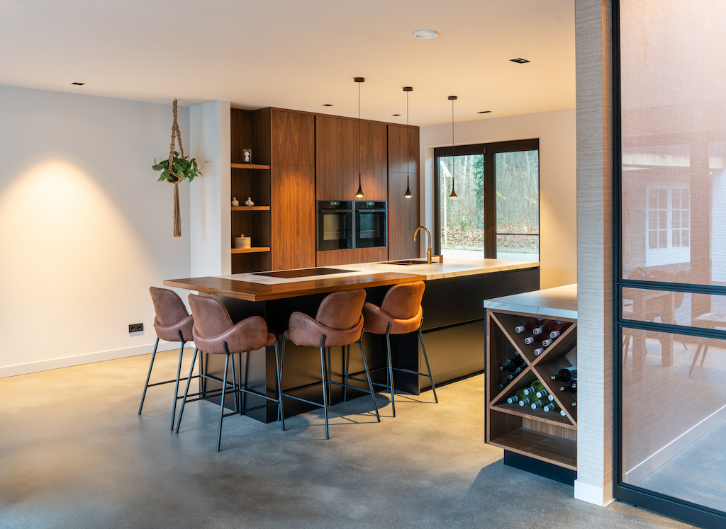 Keuken op maat met kookeiland, bar met krukken en wijnrek, gezien vanuit de woonkamer
