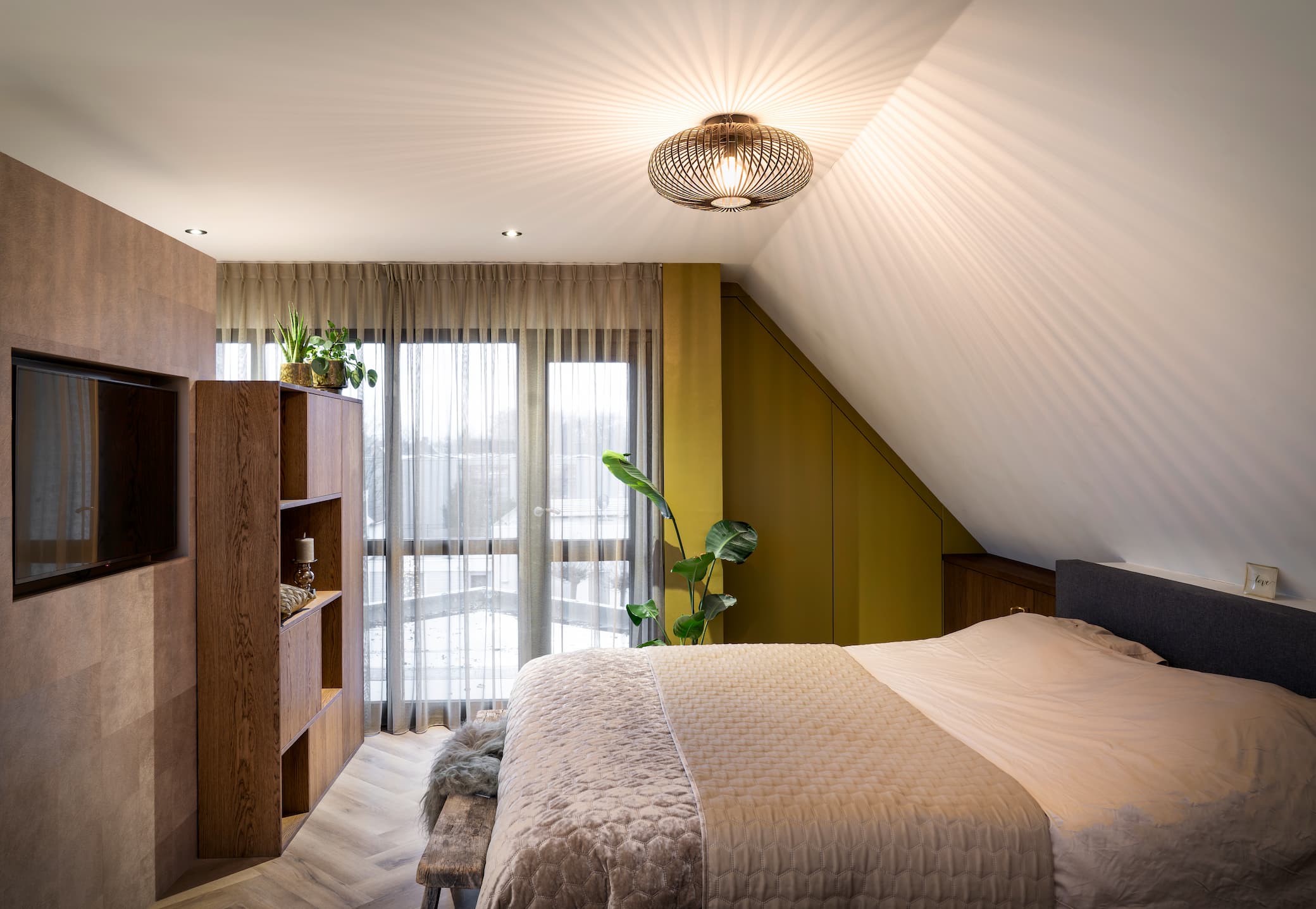 Slaapkamer met kast op maat en ingebouwde tv onder een schuin dak